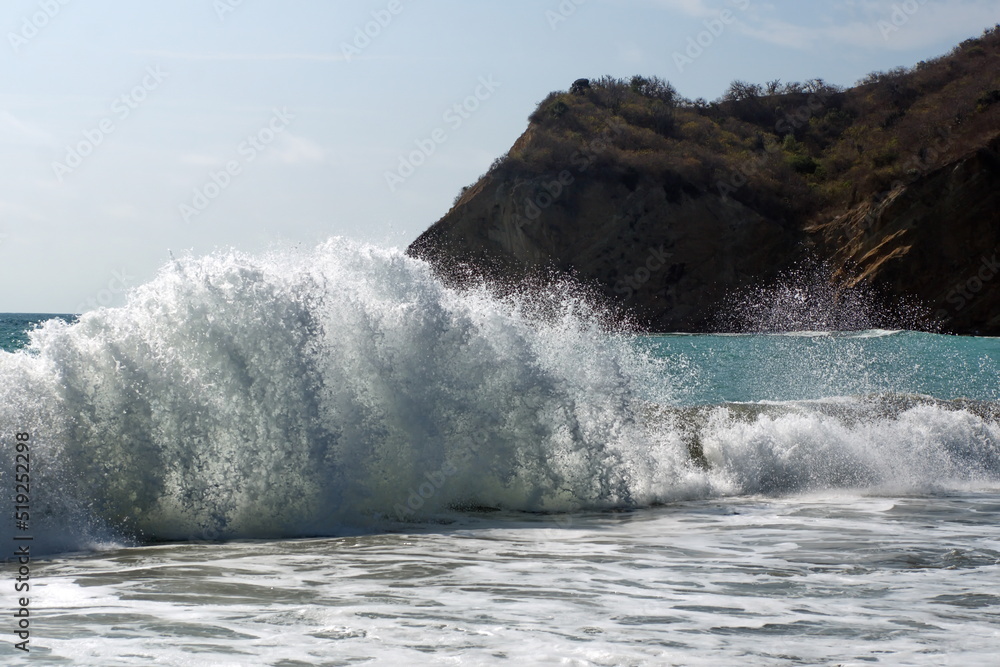 Waves breaking on the beach below the cliffs at Los Frailes Beach in Machalilla National Park, near Puerto Lopez, Ecuador
