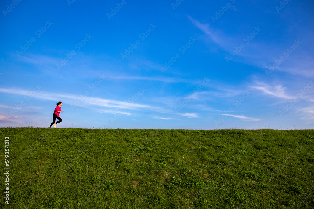Young Asian girls jogging for fitness in the open grass Young Asian girls jogging for fitness in the open grass