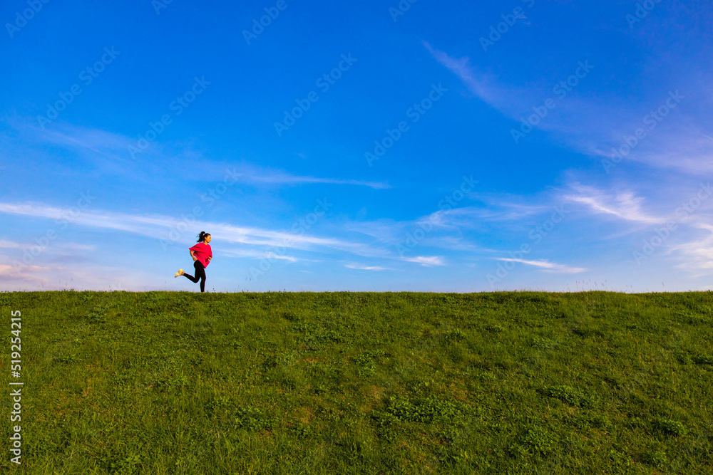 Young Asian girls jogging for fitness in the open grass Young Asian girls jogging for fitness in the open grass