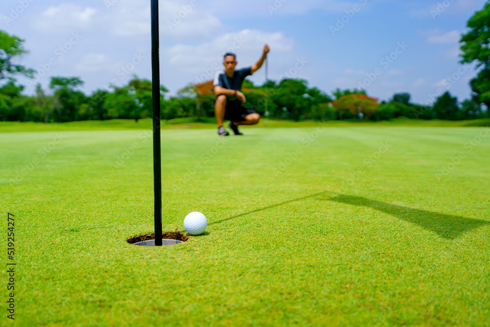 Golfer putt golf ball into hole on the green at golf course