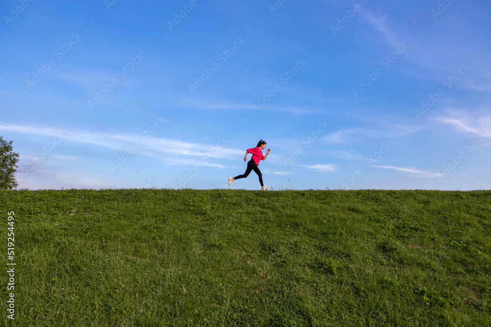 Young Asian girls jogging for fitness in the open grass Young Asian girls jogging for fitness in the open grass