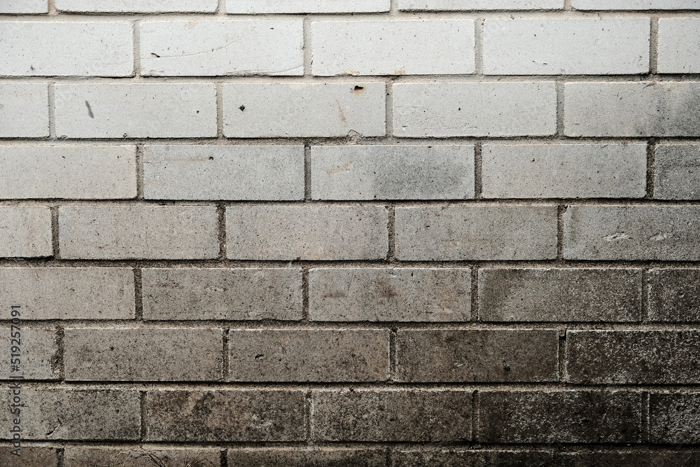 Weathered brick wall made from white bricks with white mortar, showing surface wear, scuffs and discoloration Weathered brick wall made from white bricks with white mortar, showing surface wear, scuffs and discoloration