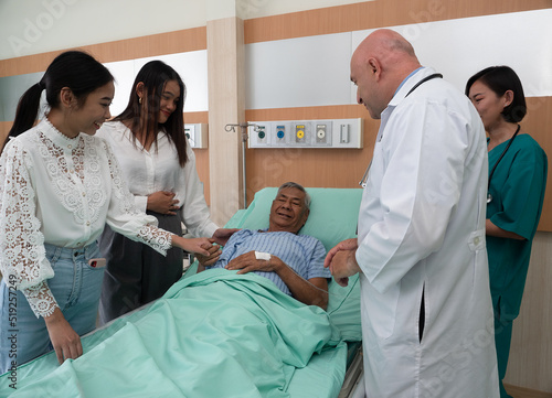 Принти на полотні In hospital treatment room relative visit patient holding hand and doctor explai