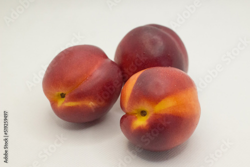 three nectarines on a white background