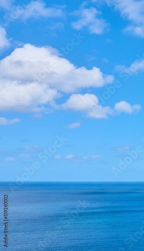 Copy space at the sea with a cloudy blue sky background above the horizon. Panoramic of calm ocean waters across a beach shore. Peaceful scenic coastal landscape for a relaxing and zen summer getaway