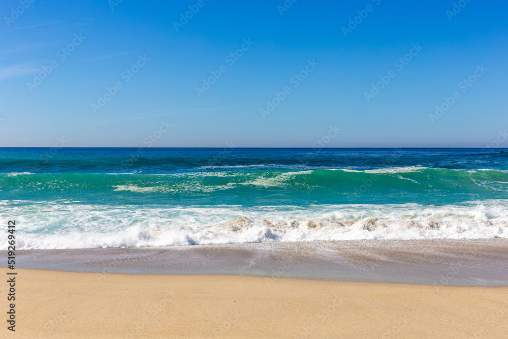 A view on Pacific ocean coast with blue sky and water and waves