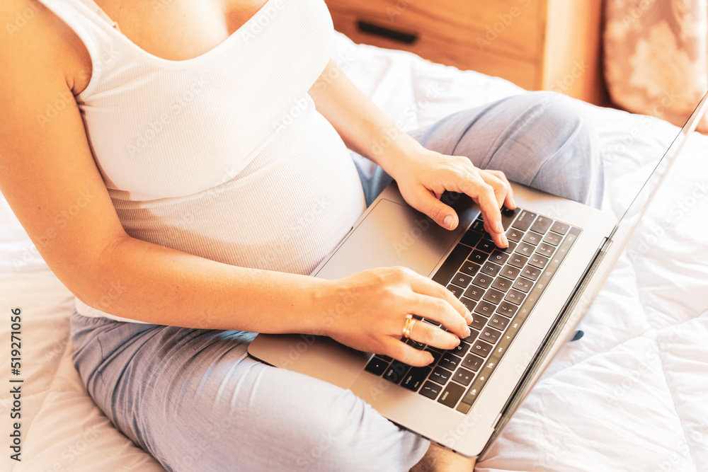 Naklejka premium Pregnancy digital laptop. Pregnant woman holding digital computer. Mobile pregnancy online maternity notebook application. Concept of pregnancy, maternity, expectation for baby birth.