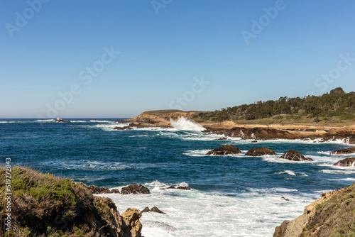 A view on Pacific ocean coast with blue sky and water and waves