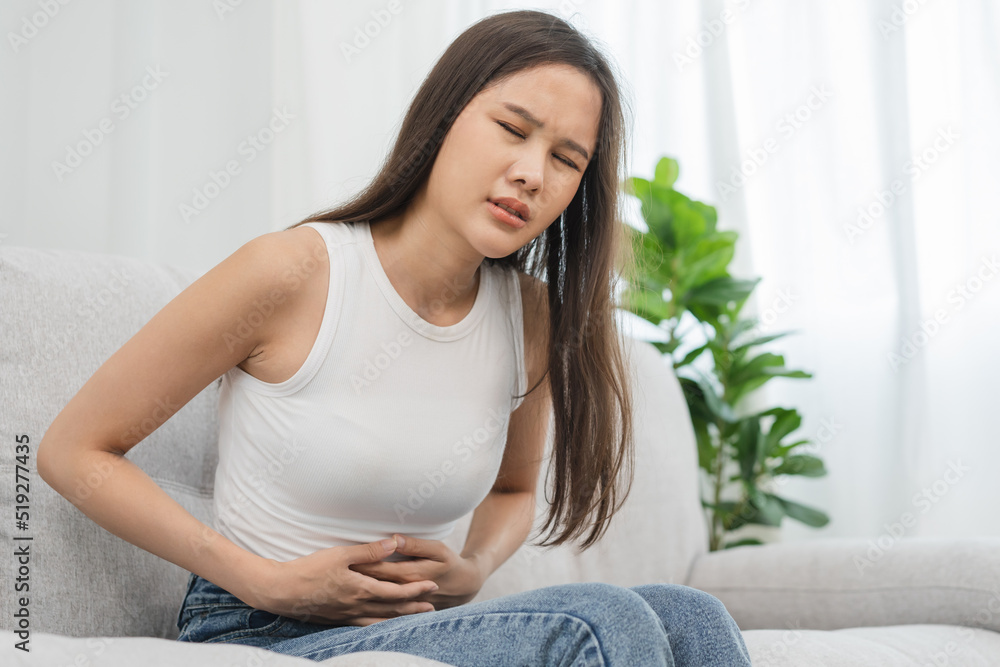 Flatulence asian young woman, girl hand in stomach ache, suffer from food poisoning, abdominal pain and colon problem, gastritis or diarrhoea. Patient belly, abdomen or inflammation, concept.