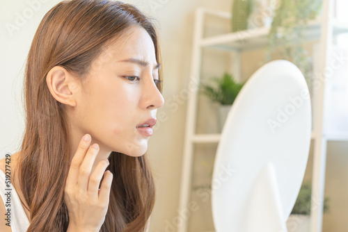 Foto Dermatology, puberty asian young woman, girl looking into mirror, allergy when wear mask and cosmetic, show squeezing pimple spot for removing from face