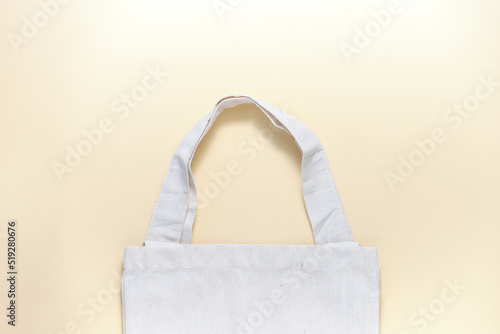 Beige textile eco shopping bag for groceries on a beige background. The concept of minimizing consumption, zero waste, reducing the amount of non-degradable waste.