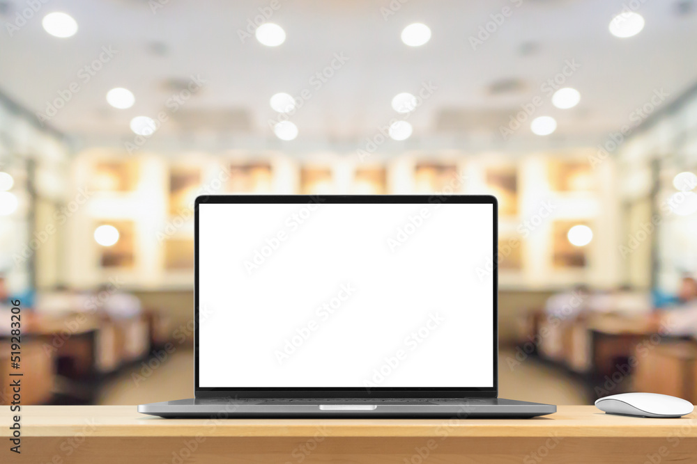 Laptop with blank screen on wood table with cafe coffee shop blur background Laptop with blank screen on wood table with cafe coffee shop blur background
