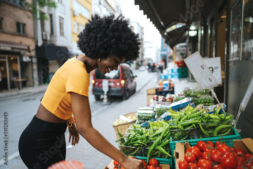Foto Young African American woman shopping at a local street market