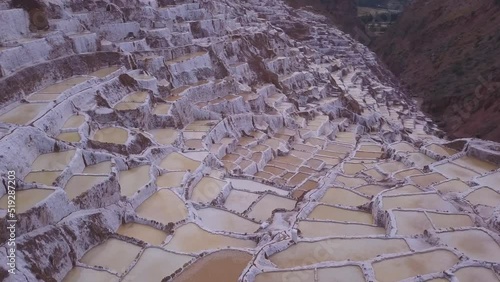 Salineras de Maras (Salinas), traditional salt mine pan with white terrace basin ponds , scenic tourist landmark in Urubamba sacred valley near Cusco in Peru, South America. (aerial photography) photo