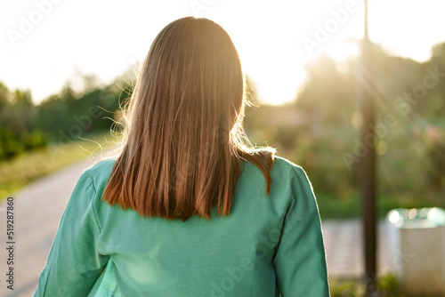 Brunette woman standing backwards in the park