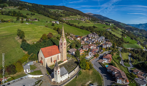 Villandro, Italy - Aerial view of the Church of St.Michael at the small village of Villandro (Villanders) on a sunny summer day with blue sky in Bolzano photo