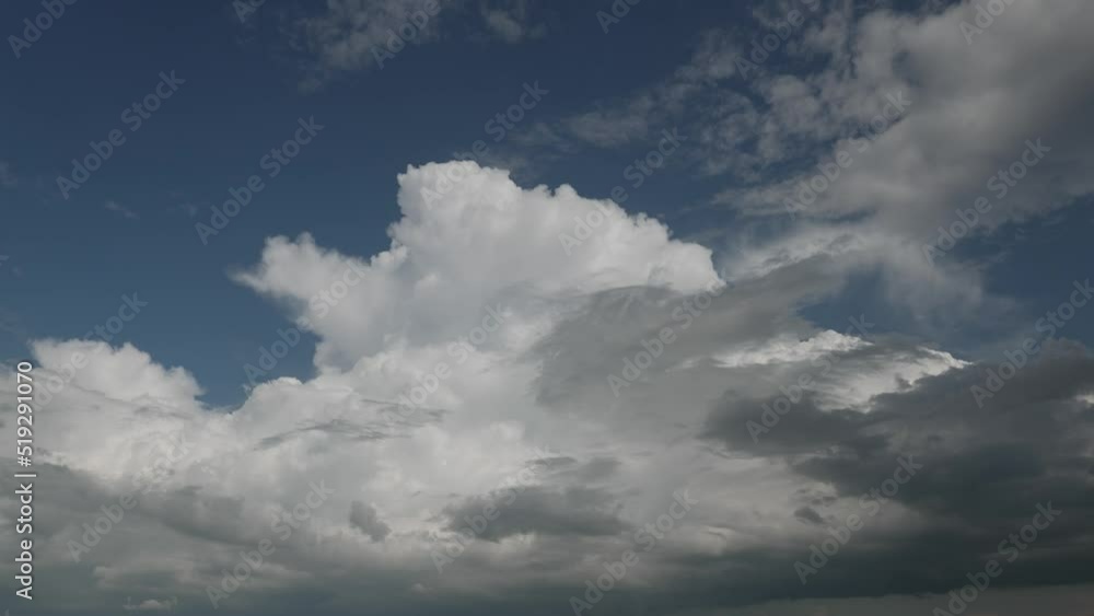 Gray puffy clouds forming and sliding in dark blue sky; static timelapse Gray puffy clouds forming and sliding in dark blue sky; static timelapse