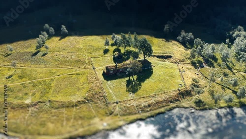 A tilt-shift video of a traditional sod roof house on the river bank. Slow-motion, orbit. photo