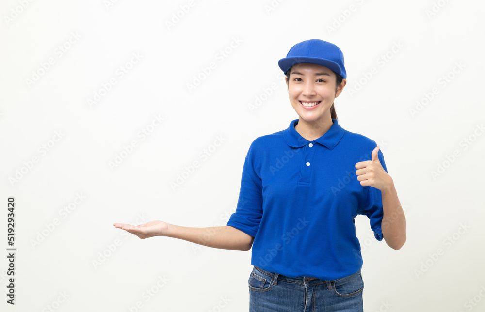 Happy delivery asian woman in blue uniform standing palm up hand to blank space for text advertise on isolated white background. Smiling female delivery service worker.