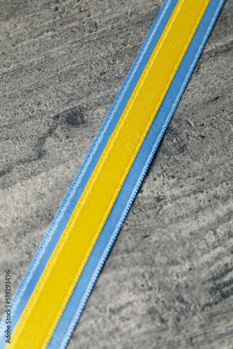 Ribbons in Ukrainian flag colors on gray wooden background