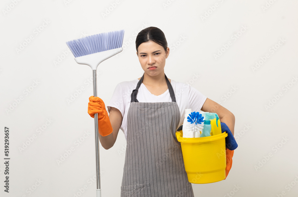 Young housekeeper woman holding bucket of cleaning products ready for cleaning home on isolated white background. Young housekeeper woman holding bucket of cleaning products ready for cleaning home on isolated white background.