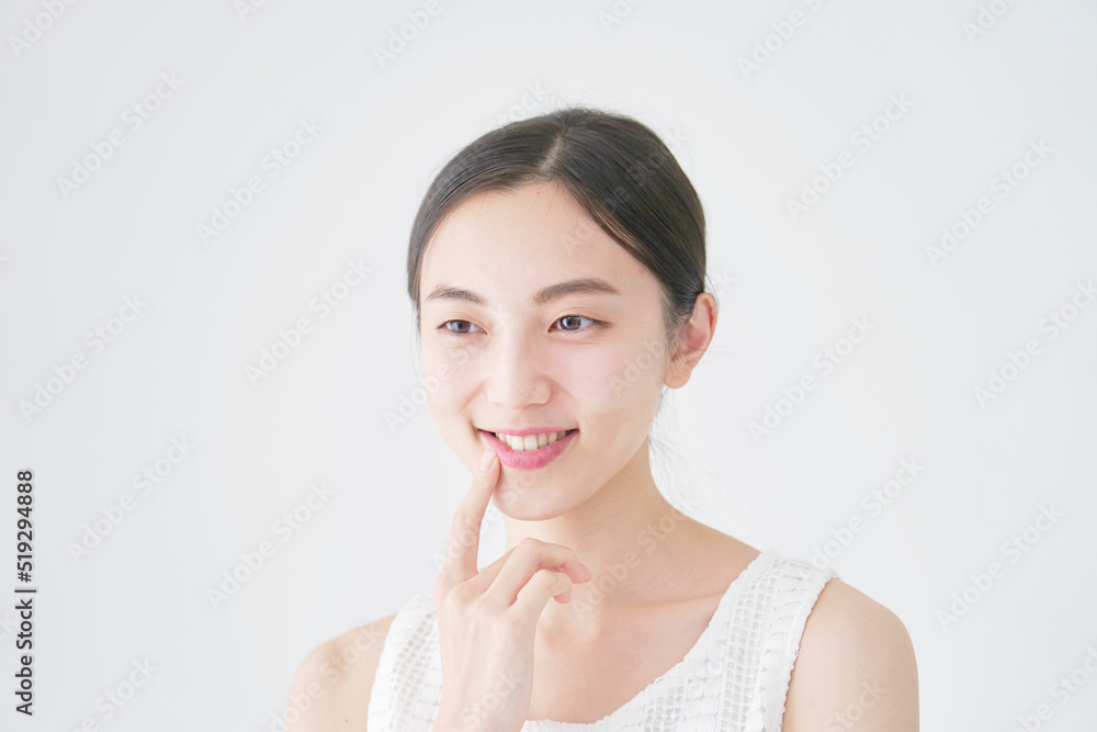 白バックで口元を指差す女性 白バックで口元を指差す女性