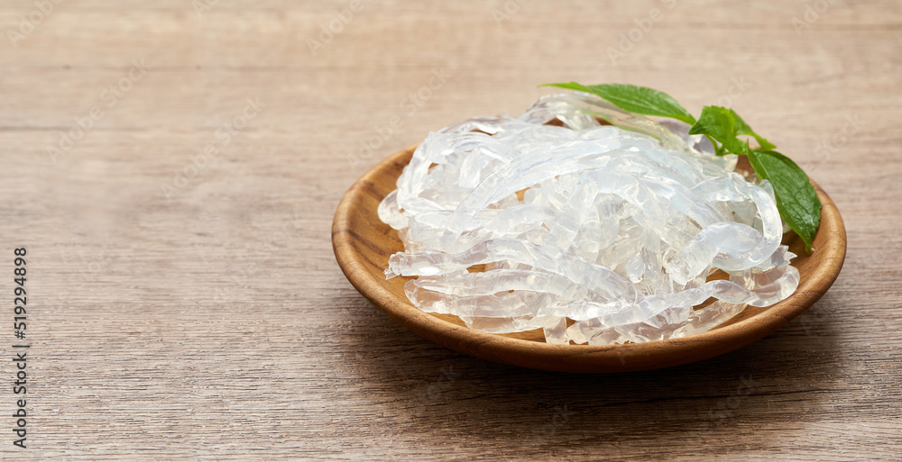 clear kelp or seaweed noodle in a wooden plate on wooden background. glass noodle                                  