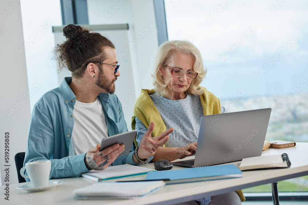 An educator helping female senior student to master the material. An educator helping female senior student to master the material.