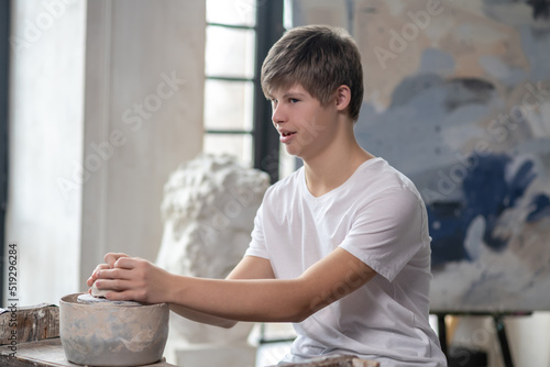 A boy making a pot in an art studio photo