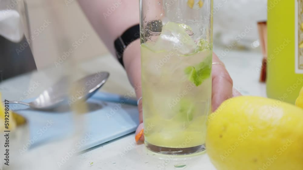 Lady making mojito at a fancy art exhibit event. lady stirring a mojito drink. Lady making mojito at a fancy art exhibit event. lady stirring a mojito drink.