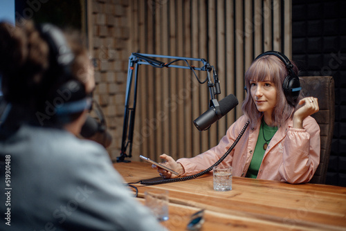 Obraz na płótnie Young woman host talking to microphone and interviewing a man for a radio podcast