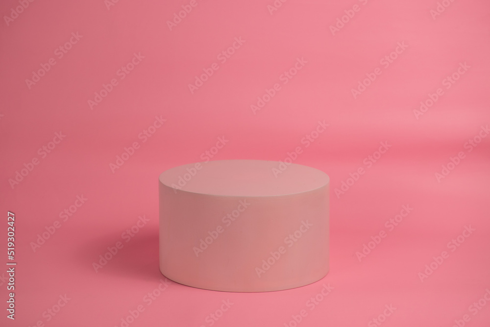 Empty podium for display cosmetic product. Platform arrangement in pink pastel color in trendy minimalist style. Composition of cylinders and cubes layout for feminine background