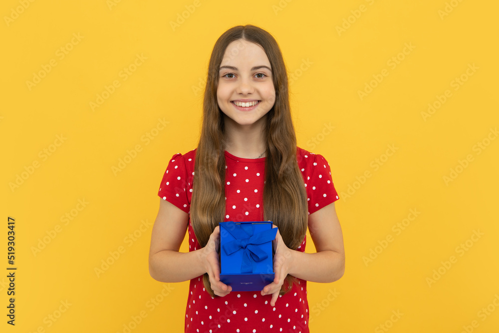 Teenager child girl holding present box isolated over yellow studio background. Present, greeting and gifting concept. Birthday holiday concept. Teenager child girl holding present box isolated over yellow studio background. Present, greeting and gifting concept. Birthday holiday concept.