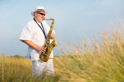 Canvas Print Man playing jazz on saxophone in the spring nature on a sunny day