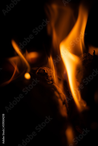 Fire close-up and red orange yellow color detail texture and abstract shape on black background © tripvisualstudio