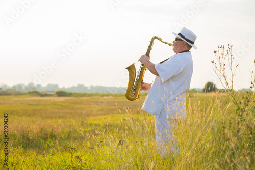 Canvas Print Man playing jazz on saxophone in the spring nature on a sunny day