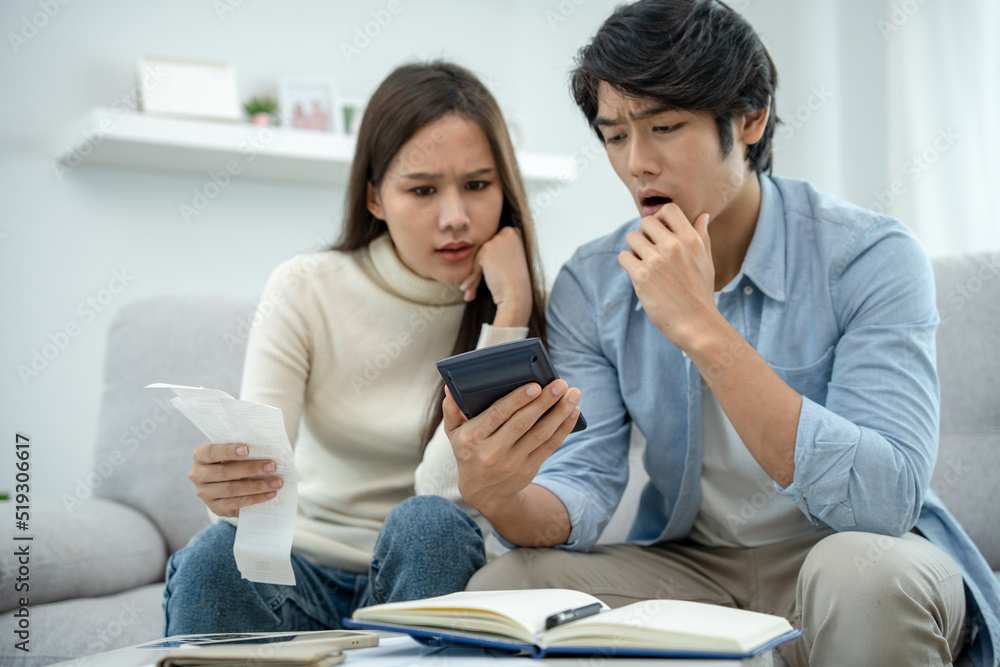 Asian couples are worried about debt and expenses. Stressful women and men receive bank loan invoices. credit card , water, electricity , telephone bills. No money and broke Asian couples are worried about debt and expenses. Stressful women and men receive bank loan invoices. credit card , water, electricity , telephone bills. No money and broke