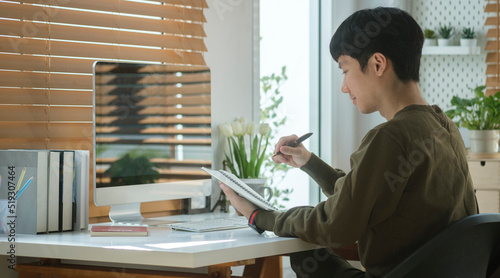 Side view young businessman working in modern home office.