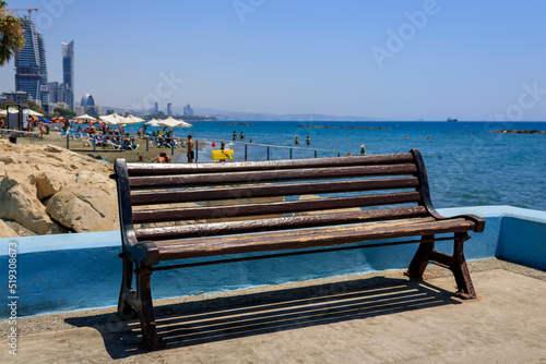 Empty old wooden bench at summer sea beach in Limassol, Cyprus © Olga