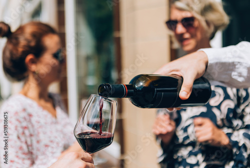 Photos pouring red wine on glass at the aperitif happy hour wine tasting