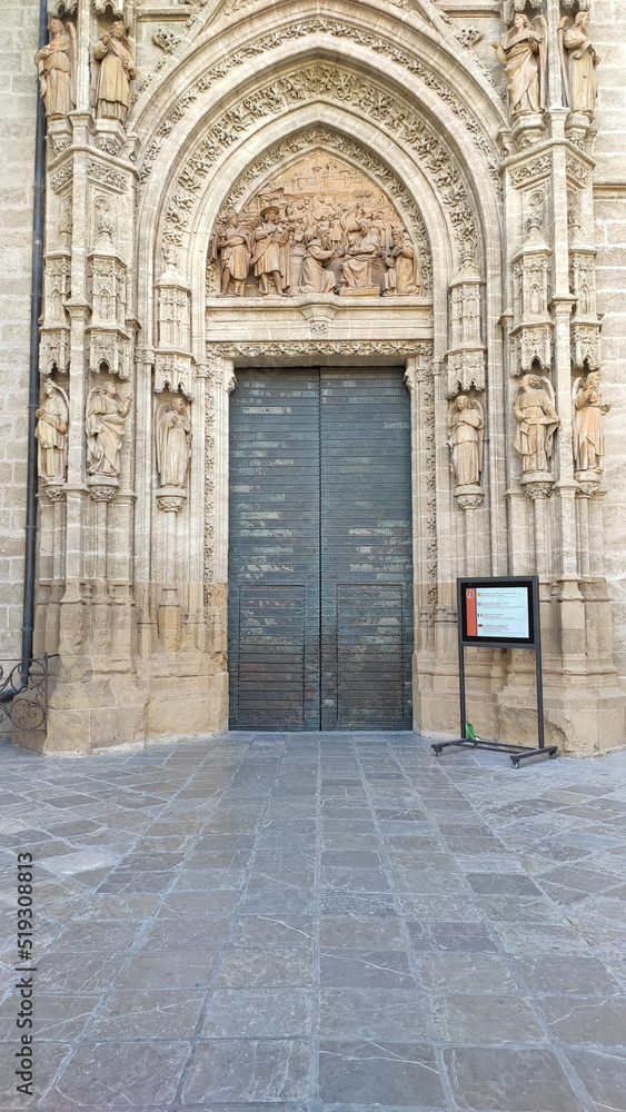 Seville, Spain, September 11, 2021: Detail of Main door of the Assumption of Saint Mary of the See Cathedral, in the center of the west facade, is well-preserved and elaborately decorated.