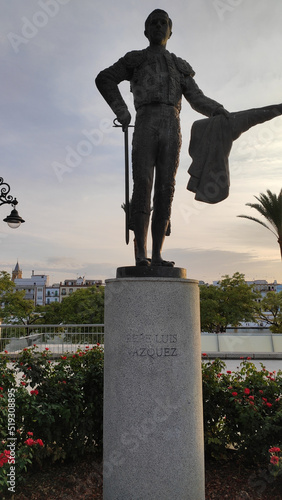 Seville, Spain, September 12, 2021: Bronze statue of Pepe Luis Vazquez, matador de toros, by Alberto German Franco, 2003, in front of the main entrance of the bullring of the Real Maestranza. photo