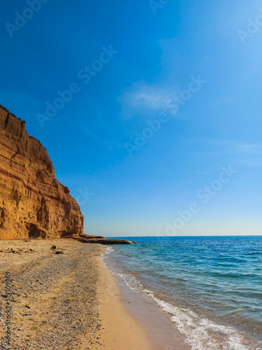 Inspiring summer sea, sand beach landscape view with beautiful blue sky with white clouds, sunlight and clay rocks