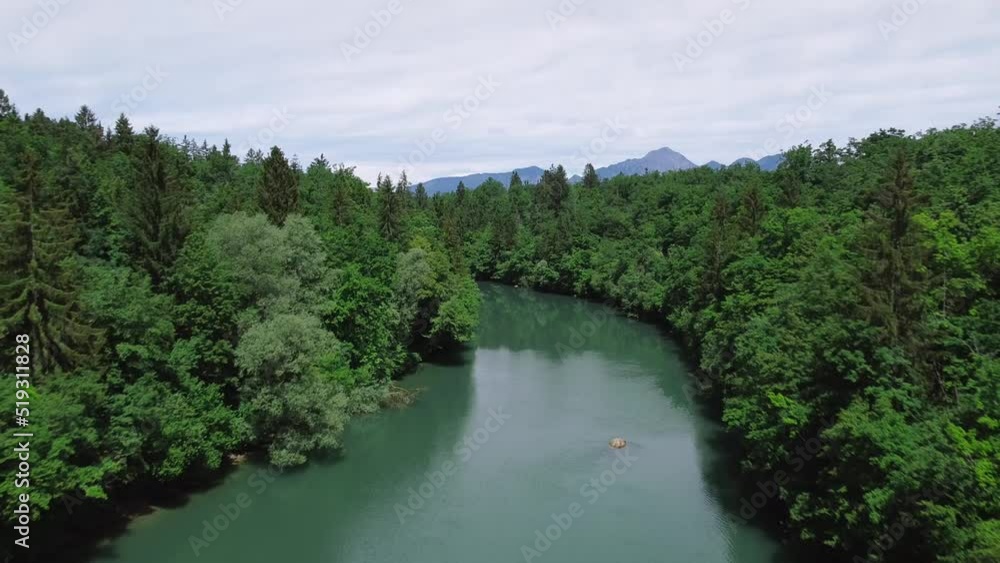 Flying across a green river, surrounded by forest. Flying across a green river, surrounded by forest.
