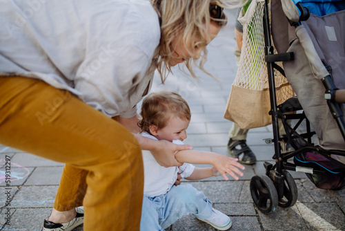 Foto Young mother comforting crying little girl outdoor on walk