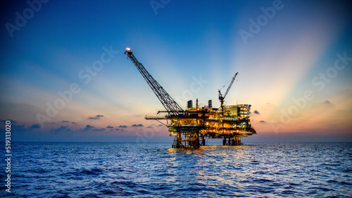 Foto Offshore oil and rig platform in sunset or sunrise time