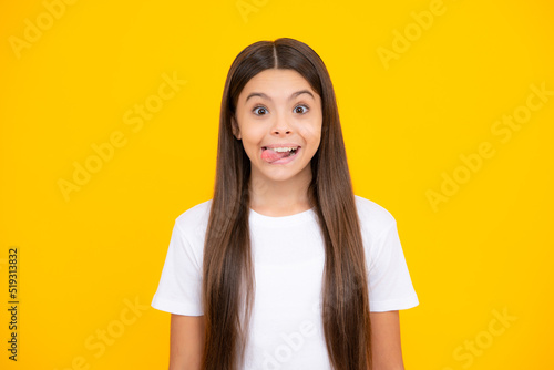 Funny kids face. Portrait of silly teenager child girl smiling and showing tongue in camera making funny faces. photo