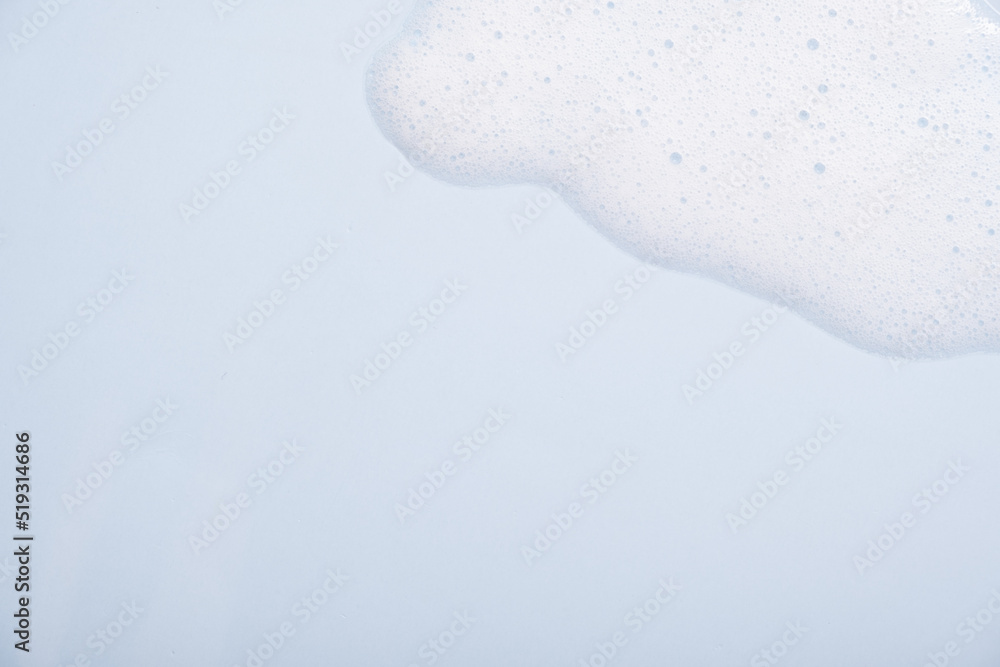 Face cleansing mousse sample. White cleanser foam bubbles on blue background. Soap, shower gel, shampoo foam texture closeup Face cleansing mousse sample. White cleanser foam bubbles on blue background. Soap, shower gel, shampoo foam texture closeup