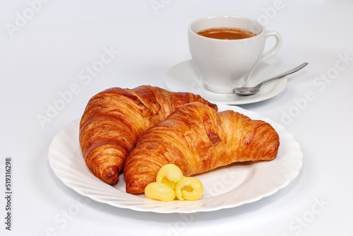 Two croissants with butter on a white plate and a cup of coffee on a white background. Croissant on white plate isolated over white background.