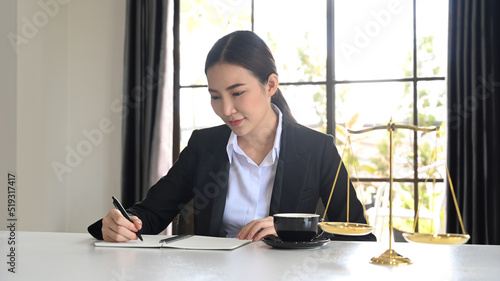 Female lawyers working with contract papers in the office and brass scale on white table © Prathankarnpap